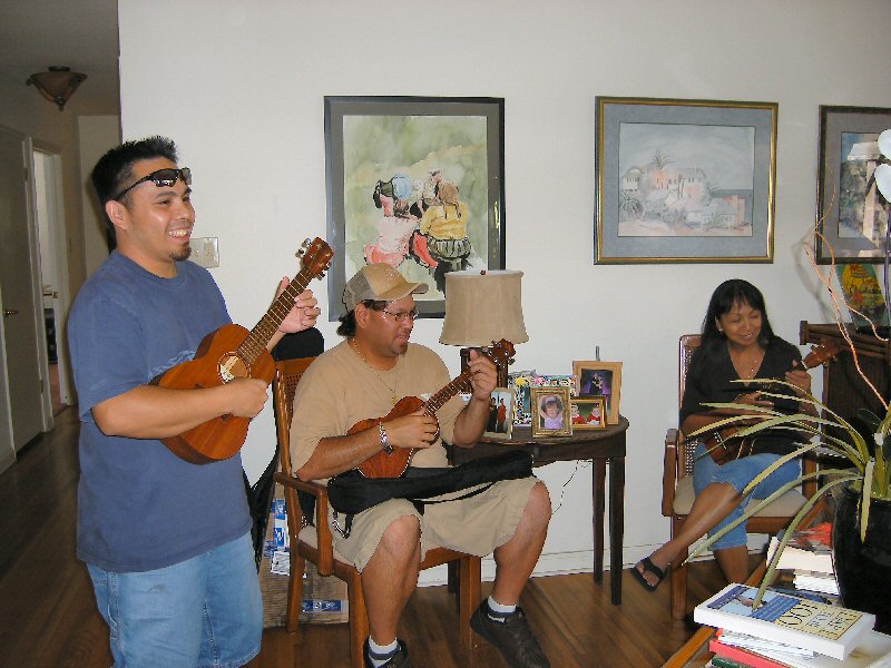 3 people playing uke in the living room